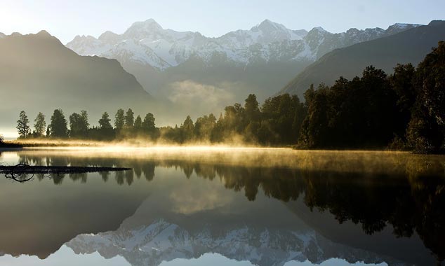 Lake Matheson reflects the snow-capped mountains.