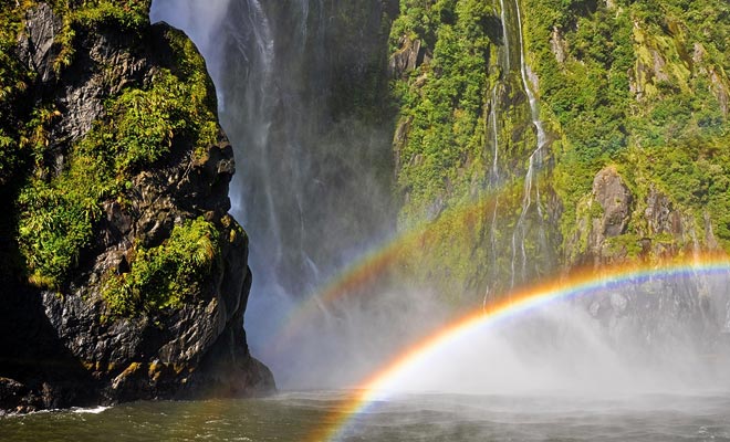 The hundreds of waterfalls that form due to the rain are swept by the wind. Moisture in the air reveals many rainbows.