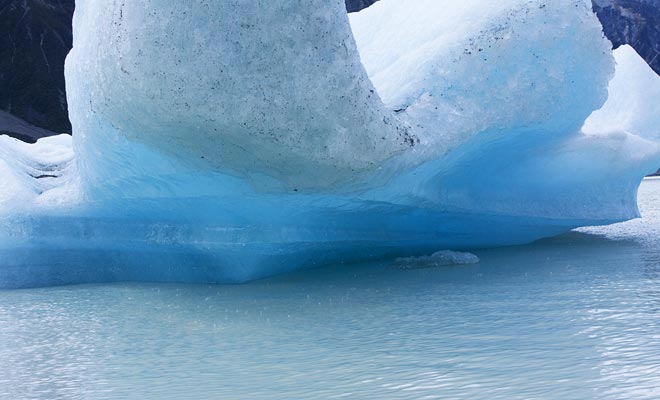 When an iceberg rotates on itself, it reveals the part that was hidden underwater. It turns bright blue under the rays of the sun.