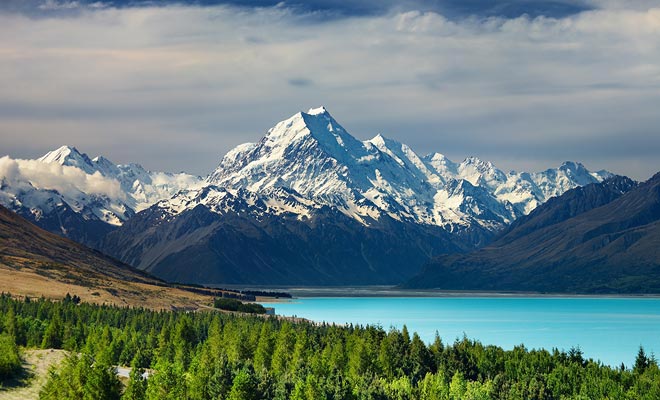 Starting from Twizel, a road runs along the Pukaki Lake towards the Hermitage village. The turquoise lake reflects the snow-capped Mount Cook.